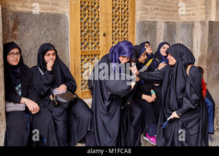 Isfahan, Iran - 24. April 2017: Iranische Frauen in hijabs auf der Straße in der Nähe der Wand und reden miteinander. Stockfoto