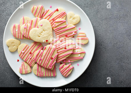 Vanillezucker schneiden Sie Cookies mit rosa Glasur und Streuseln für Valentines Tag Stockfoto