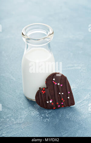 Schokolade Herzen Cookie mit Streuseln für Valentines Tag mit einer Flasche Milch Stockfoto