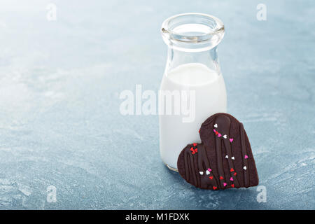 Schokolade Herzen Cookie mit Streuseln für Valentines Tag mit einer Flasche Milch Stockfoto