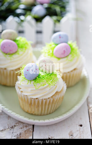 Ostern Vanille Cupcakes mit Frischkäse Zuckerguss und egg candy Stockfoto