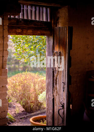 Ein rustikales Holz Stall Tür mit einem Herzförmigen Kranz auf aufhängen. Stockfoto