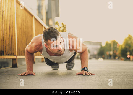 Porträt eines Fitness Mann tun Push-ups im Freien. Fitness, Sport, Lifestyle Konzept Stockfoto