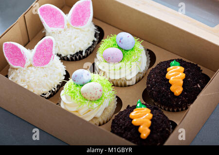Sortiment an Ostern cupcakes in einem Kasten mit Hasenohren und Candy Eier Stockfoto