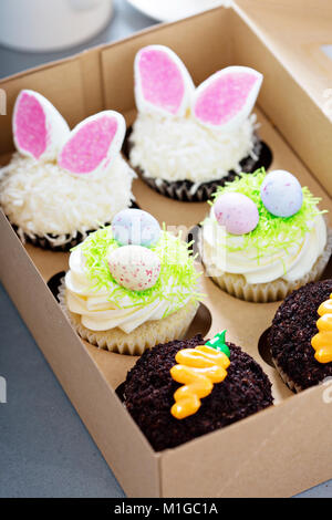 Sortiment an Ostern cupcakes in einem Kasten mit Hasenohren und Candy Eier Stockfoto