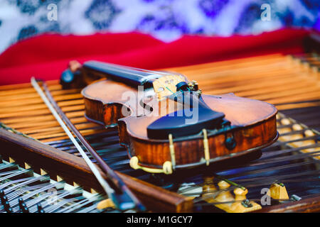 Violine im Detail bei der Becken. Hackbrett und Violine mit einer geringen Tiefenschärfe und selektiven Fokus auf der Brücke der Violine Stockfoto