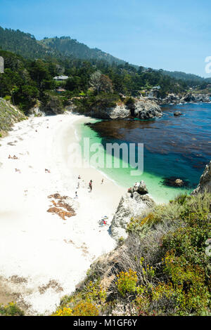 Sonnenanbeter am Strand von Point Lobos State Park entspannen, in der Nähe von Carmel Highlands, entlang der Autobahn 1, Monterey County, Kalifornien. Stockfoto