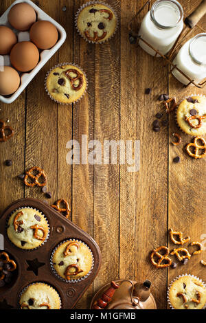 Chocolate Chip und Brezel Muffins mit Milch auf hölzernen Hintergrund für Dessert overhead Shot mit Kopie Raum Stockfoto