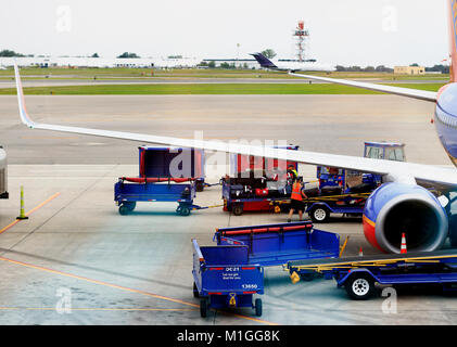 Arbeitnehmer und Fahrzeuge Handhabung luagges Neben warten Boeing 737 in Buffalo Niagara International Airport, New York State, USA Stockfoto