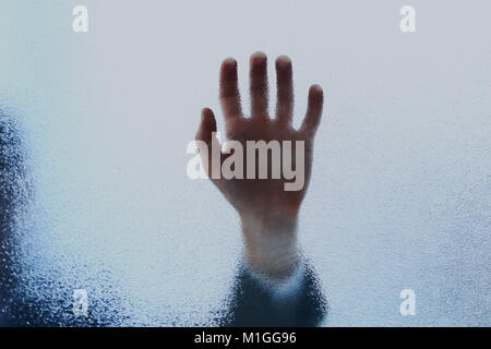 Eine Handvoll lehnte sich auf sandgestrahlte Glasplatte. Stockfoto