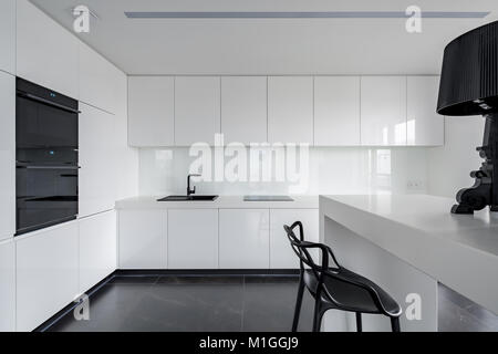 Ausgeklügelte schwarze und weiße Küche Einrichtung mit einfachen Tisch und Stuhl Stockfoto