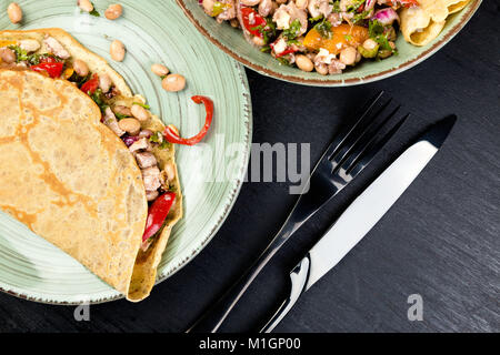 Herzhafte Buchweizen Pfannkuchen mit weißen Bohnen, Rote und gelbe Paprika, Petersilie und Huhn. Mexikanische Quesadilla. Ansicht von oben. Stockfoto