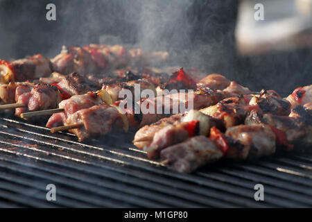 Kebab auf holzspieße am Grill. Schaschlik oder shashlyk - fleischspieße am Grill. Shish Kebab auf einem Grill. Gebratenes Fleisch am Grill. Selektiver Fokus Stockfoto