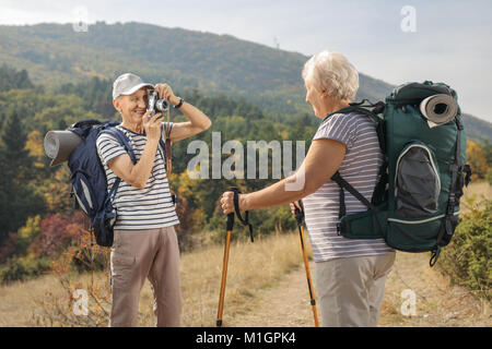 Ältere männliche Wanderer ein Bild von einem älteren weiblichen Wanderer im Freien Stockfoto