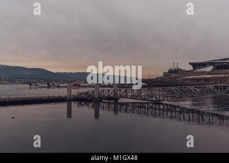 Vancouver, British Columbia/Kanada - 24. Dezember 2017: Coal Harbour Bucht - am Wasser in der Innenstadt mit Bergen im Hintergrund. Stockfoto