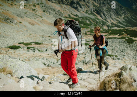 Backpackers Nordic Walking in der Hohen Tatra auf einem hellen, sonnigen Tag. Stockfoto