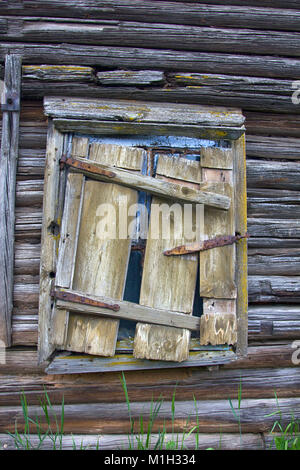 Alltägliche Objekte in Museen und verlassenen alten Häusern. Fenster aus Holz haus mit Eingestürzten shutter closed, Sterbende russischen Dorf. Stockfoto