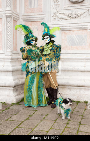 Venedig, Italien - 22. Februar 2017: Karneval in Venedig - Paar schöne venezianische Masken mit kleinen Hund in bunten Elegantes Kostüm San Zaccaria. Stockfoto