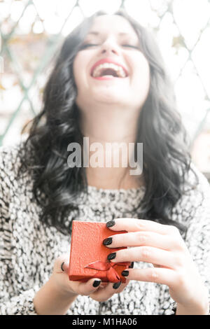 Geschenk Box outdoor mit Defokussierten portrait einer aufgeregt lächelnde Mädchen öffnen Stockfoto