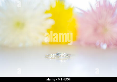 Verlobung und Hochzeit Ring auf weiße Blume Hintergrund aus glänzenden Weißgold und Diamanten Stockfoto