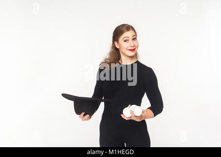 Glück Frau mit jongleur Kugeln und Hut. Studio shot, auf weißem Hintergrund Stockfoto