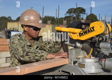 PORT HUENEME, Calif (Jan. 24,2018) Builder dritte Klasse Jorowen Vinluan, zugeordnet zu den Naval Mobile Konstruktion Bataillon Fünf (NMCB 5), verwendet eine Dewalt compound Mitre saw zu Kürzungen für eine Außenwand. NMCB 5 ist die Durchführung von Schulungen zu helfen, die Sicherheit, die richtige Technik Verwendung, gewährleisten und neue Seabees mit der Ausrüstung vertraut machen in der Vorbereitung für eine bevorstehende Bereitstellung. (U.S. Marine Stockfoto