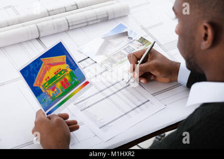 Nahaufnahme eines Architekten Berechnung von Temperatur gegen den blauen Drucken Stockfoto