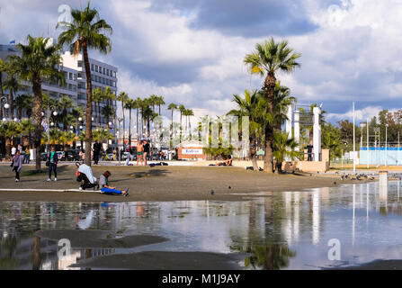 LARNACA, ZYPERN - Januar 5, 2018: Menschen auf finikoudes Beach im Januar in der Sonne entspannen. LARNACA, 5. Januar 2018 Stockfoto