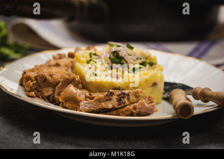 Confit Schweinekamm mit Kartoffelpüree auf steinernen Tisch Stockfoto