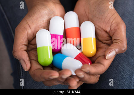 Hohe Betrachtungswinkel und einer menschlichen Hand mit Vielzahl von Medizin Pillen Stockfoto