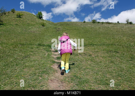 Eine bunte Kind läuft bis Cley Hill in Wiltshire UK. Die Hügel in der Nähe von Longleat ist ein beliebter Familie gehen. Stockfoto