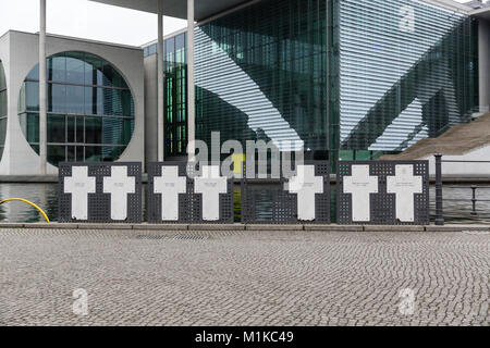 Memorial Kreuze zum Gedenken an die Opfer der Berliner Mauer an der Spree mit neben dem modernen Gebäuden der deutschen Regierung in den Hintergrund. Stockfoto