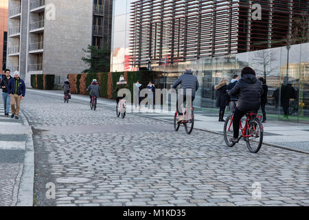 Touristen auf einem Berlin City Bike Tour Radfahren auf der Straße gepflastert mit pflastersteine entlang der Spree in der Nähe des Reichstagsgebäudes Stockfoto