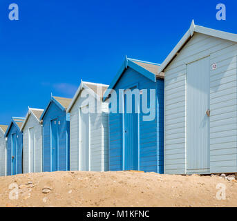 Strandhütten in Blau am Strand von Charmouth, Dorset UK Stockfoto