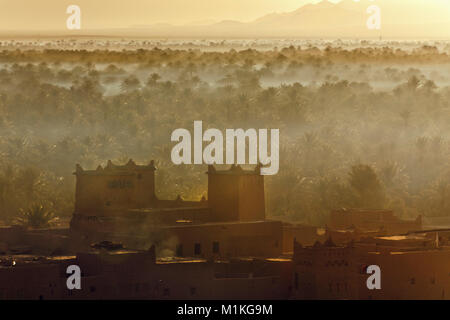 Marokko, in der Nähe von Zagora Kasbah Ziwane in der Nähe von Hotel Dar El Hiba. Sonnenaufgang über Oasis und Palmen. Kasbah und Ksar (befestigtes Dorf). Stockfoto