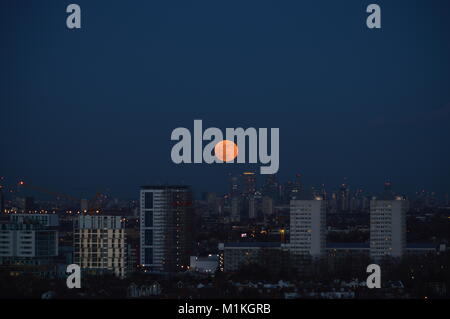 Ein super blaues Blut Mond über Canary Wharf, London, Großbritannien steigende Stockfoto