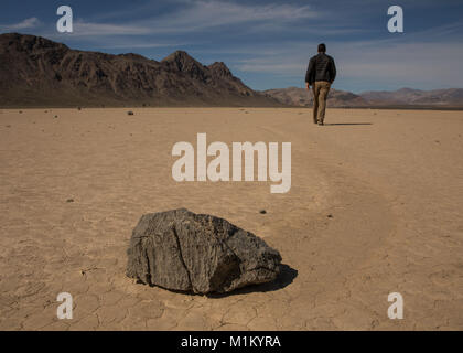 Death Valley, Kalifornien, USA. 12. März 2016. Ein Wanderer auf der "Rennstrecke" Playa im Death Valley. Die Rennstrecke ist ein Playa, ein trockener Testflugzeug, am besten bekannt für seine seltsamen beweglichen Felsen. Obwohl niemand die Felsen bewegen tatsächlich gesehen hat, bezeugen die lange gewundenen Spuren hinterlassen in der Schlamm-Oberfläche des Playa ihrer Tätigkeit. Der Park enthält eine Wüste Vielfalt des Salz-Wohnungen, Sanddünen, Badlands, Täler, Schluchten und Berge. In diesem unten Meeresspiegel Becken Sommer stetigen Dürre und Datensatz Hitze machen Death Valley ein Land der Extreme. Es ist der größte Nationalpark in den unteren 48 s Stockfoto