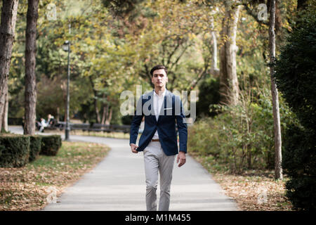 Elegante junge Mann draußen in einem Park. Stockfoto