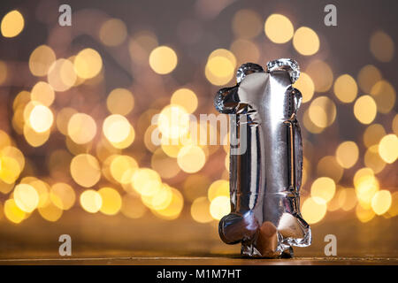 Silber Anzahl 1 Feier Folien Ballon gegen verwackelte hellen Hintergrund Stockfoto