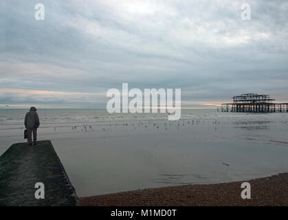 Eine einsame Figur in der Nähe der Old West Pier in Brighton Stockfoto