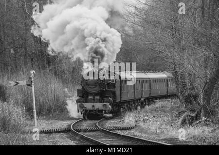 Eine schwarze und weiße mono Foto einer alten Dampflokomotive rauchen stark und vorwärts kommen Stockfoto