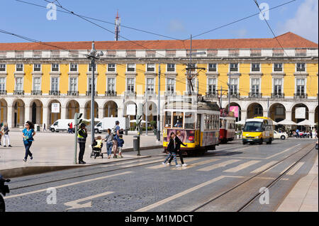 Eine elektrische Straßenbahn stoppte an einer Fußgängerampel an der Praça do Comércio mit täglichen Verkehr, Lissabon, Portugal Stockfoto