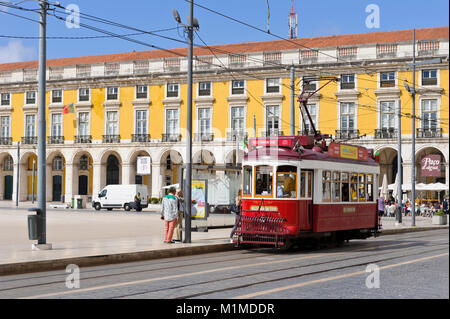 Die rote iconic Classic elektrische Straßenbahn an einer Straßenbahnhaltestelle in Praça do Comércio mit täglichen Verkehr, Lissabon, Portugal Stockfoto