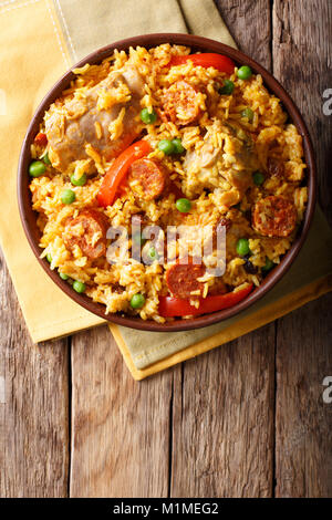 Arroz Valenciana mit Reis, Fleisch, Wurst, Rosinen, Gemüse und Gewürze aus der Nähe in einer Schüssel auf den Tisch. Senkrechte Draufsicht von oben Stockfoto