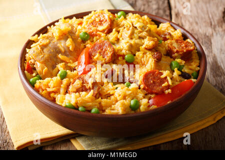 Leckeres Essen: Arroz Valenciana mit Reis, Fleisch, Wurst, Rosinen und Gemüse close-up in einer Schüssel auf dem Tisch. Horizontale Stockfoto