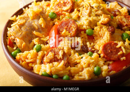 Köstliche Arroz Valenciana mit Reis, Fleisch, Wurst, Chorizo, Gemüse und Gewürze in der Nähe in einer Schüssel auf dem Tisch. Horizontale Stockfoto