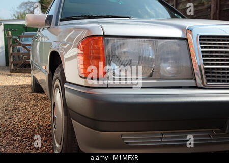 Schließen Sie herauf Bild des vorderen Scheinwerfers Bereich eines unbefleckten 1993 Mercedes Benz 190e. In Großbritannien 2017 genommen. Stockfoto