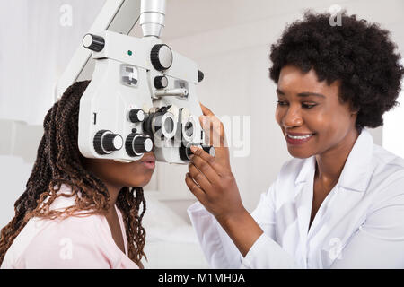 Afrikanische Optometrist tun Anblick Tests für Patienten im Krankenhaus Stockfoto