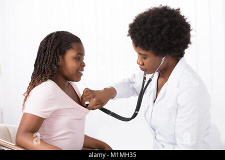 Ärztin untersucht einen Patienten mit Stethoskop im Krankenhaus Stockfoto