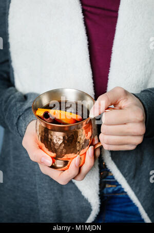 Frau mit einem kupfernen Tasse mit Glühwein Stockfoto